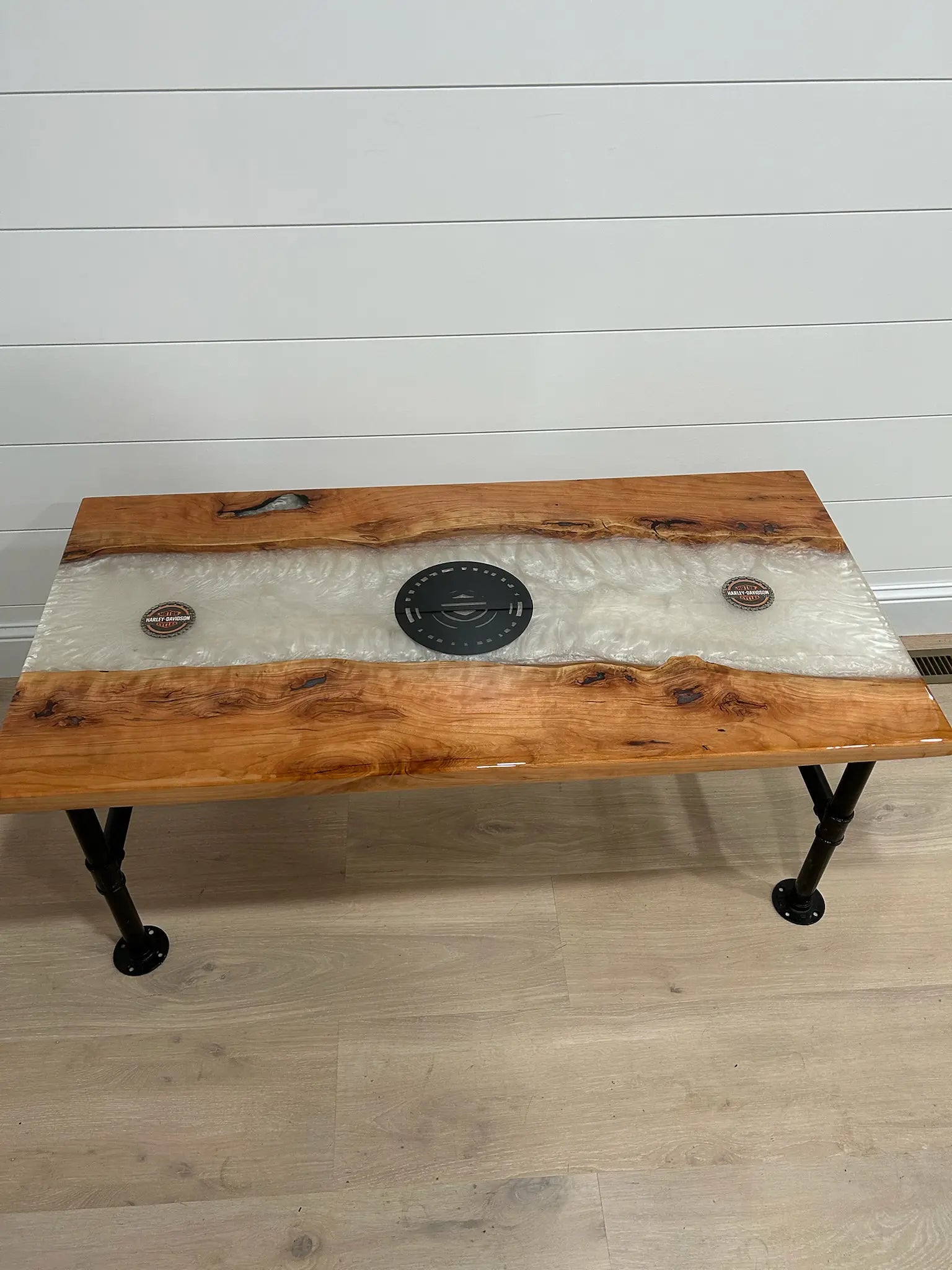 Wooden coffee table with a white marble resin top and black metal legs on a light wood floor.