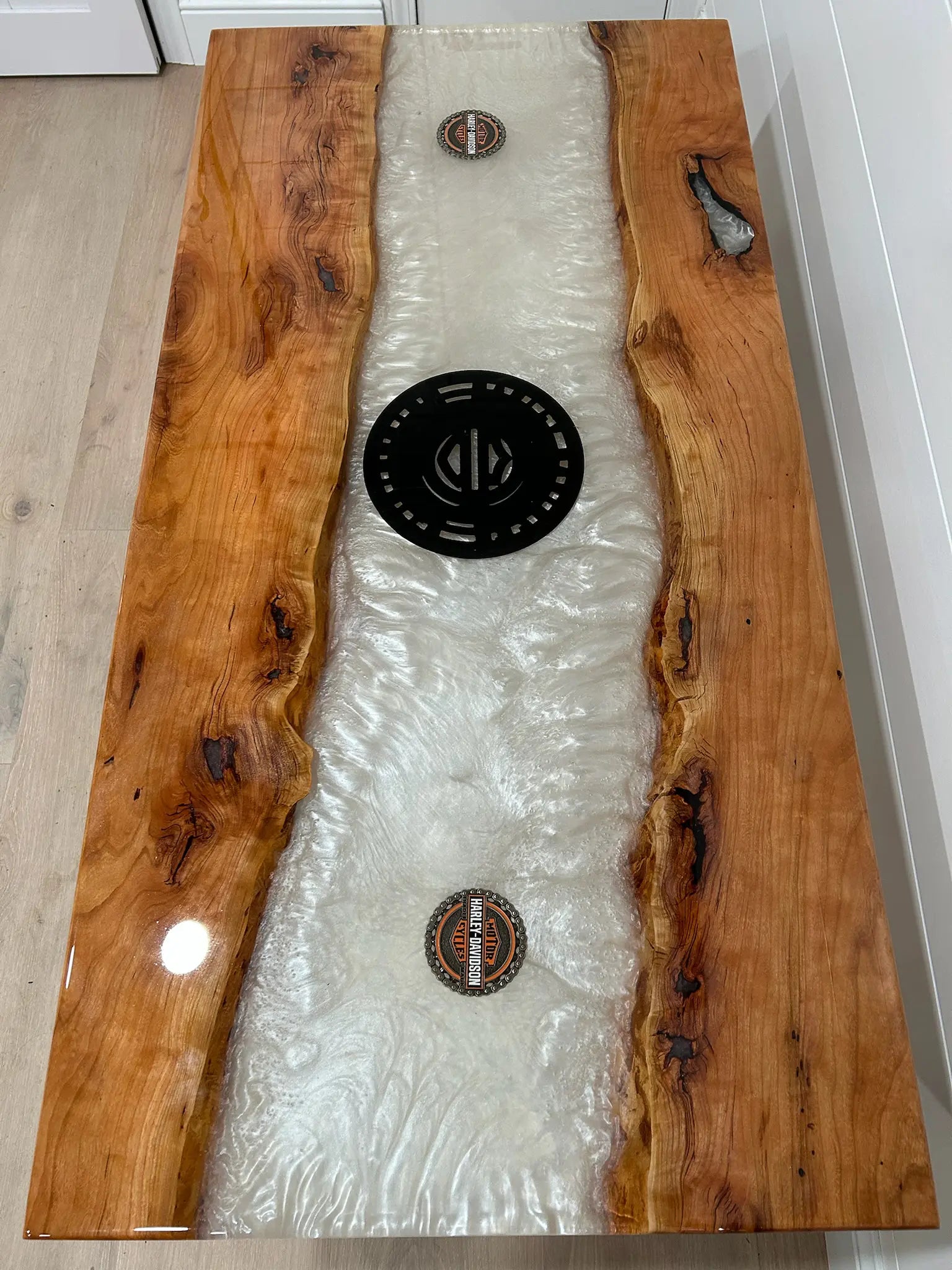Wooden coffee table with a resin inlay featuring circular designs.
