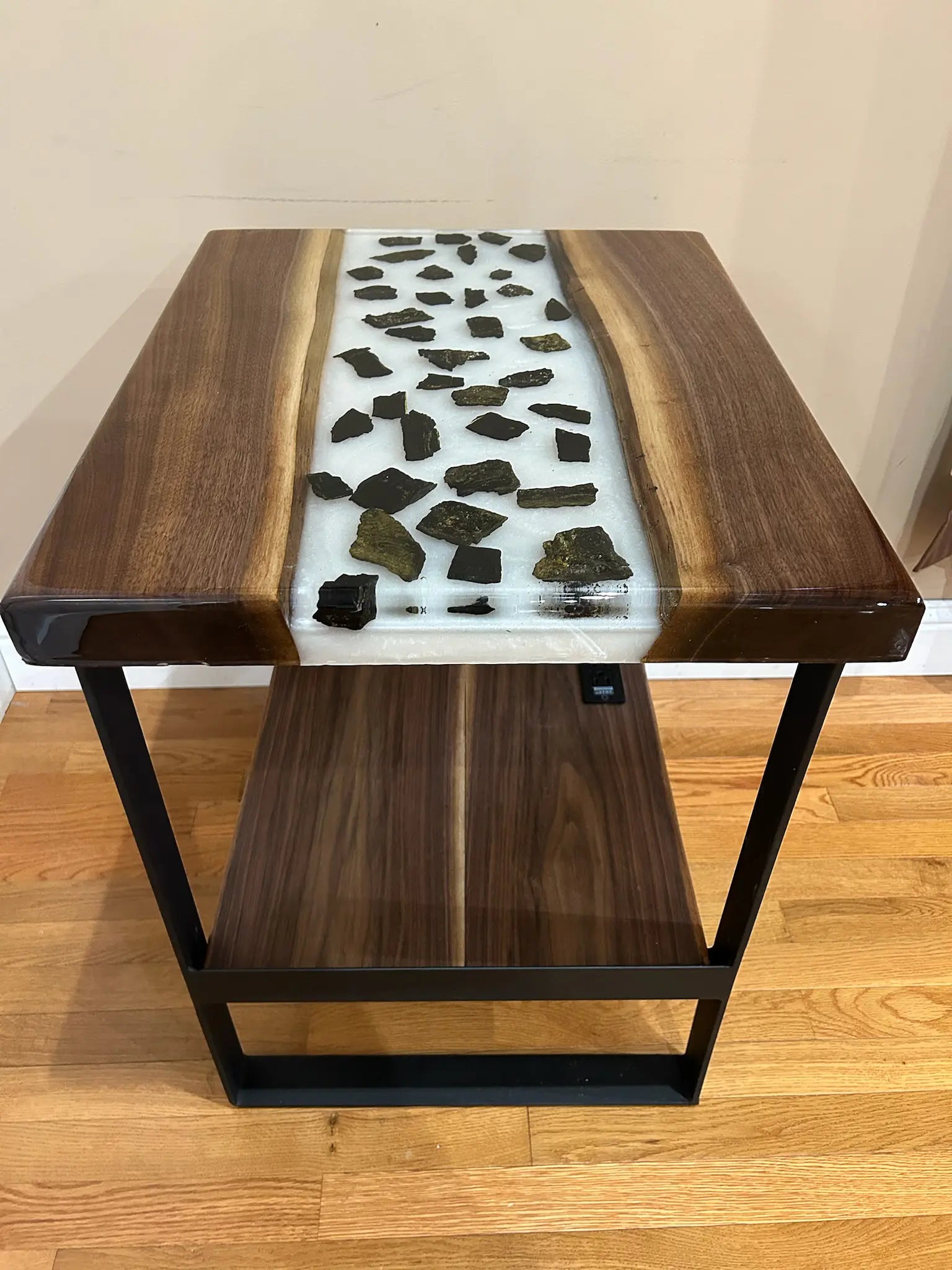 Wooden side table with a unique surface design on a wooden floor.